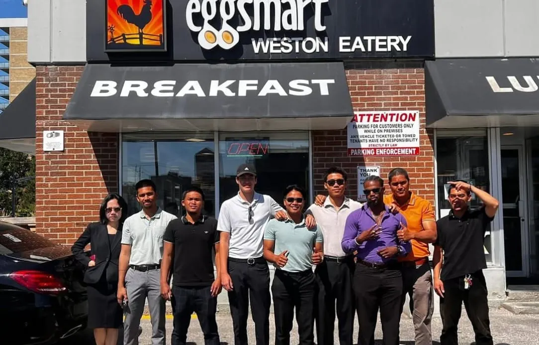 The team lined up outside a breakfast restaurant on a sunny morning.